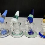 6-inch glass water pipe with a cone-shaped neck, available in four assorted colors, featuring a sturdy base and a smooth airflow design.